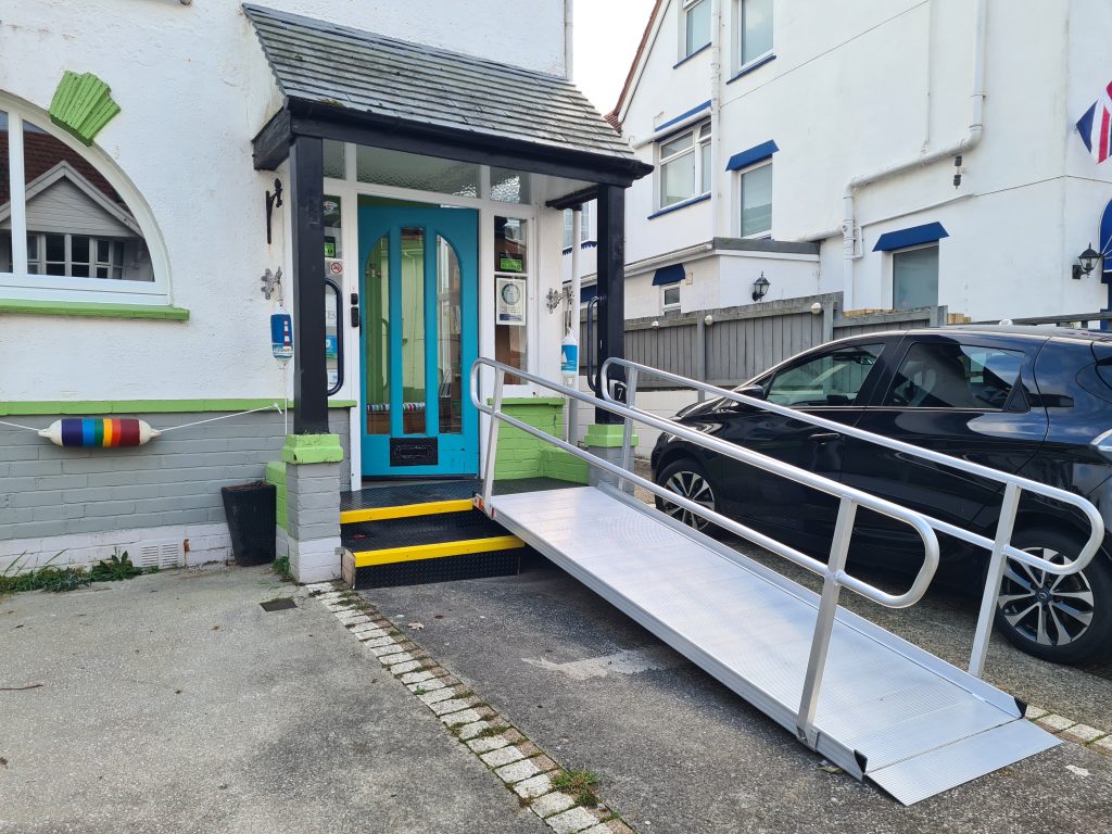 Photo of The Miggi front entrance which has clearly marked steps and a wide ramp with handrails