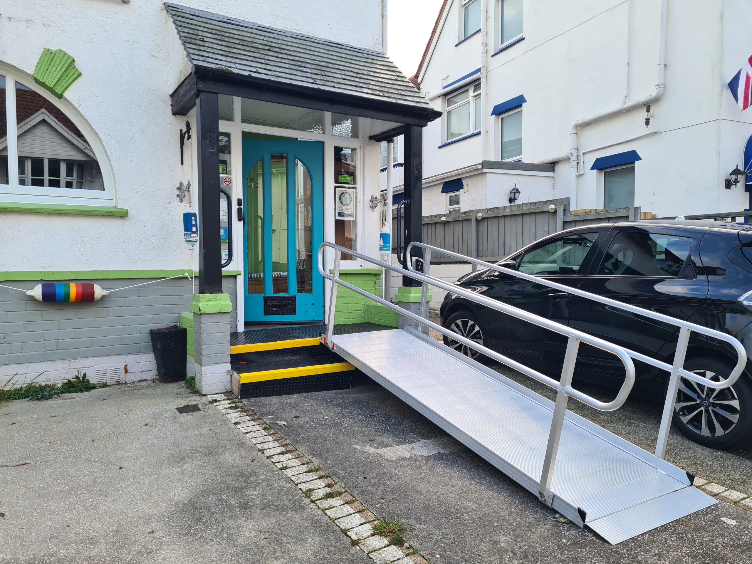 Photo of The Miggi front entrance which has clearly marked steps and a wide ramp with handrails